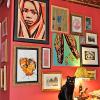 For a NYC apartment an eclectic wall grouping of different types of art against a red wall.